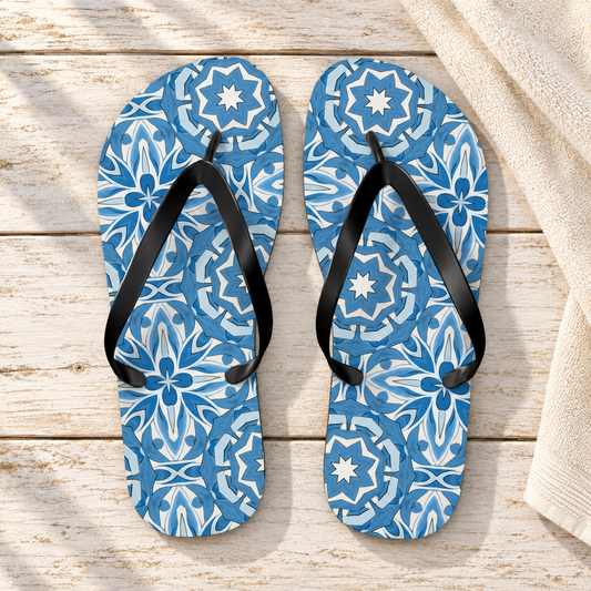 Delft Blue Star Tile Flip Flops, product-only overhead view with the printed pattern clearly visible. Setting: bleached wood seaside veranda beside a plain cream towel edge.