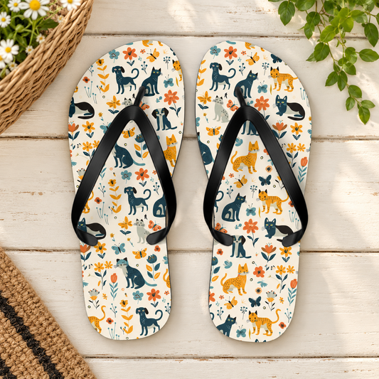 Cats & Dogs Flip Flops, product-only overhead view with the printed pattern clearly visible. Setting: cream painted cottage porch with wicker basket corner.
