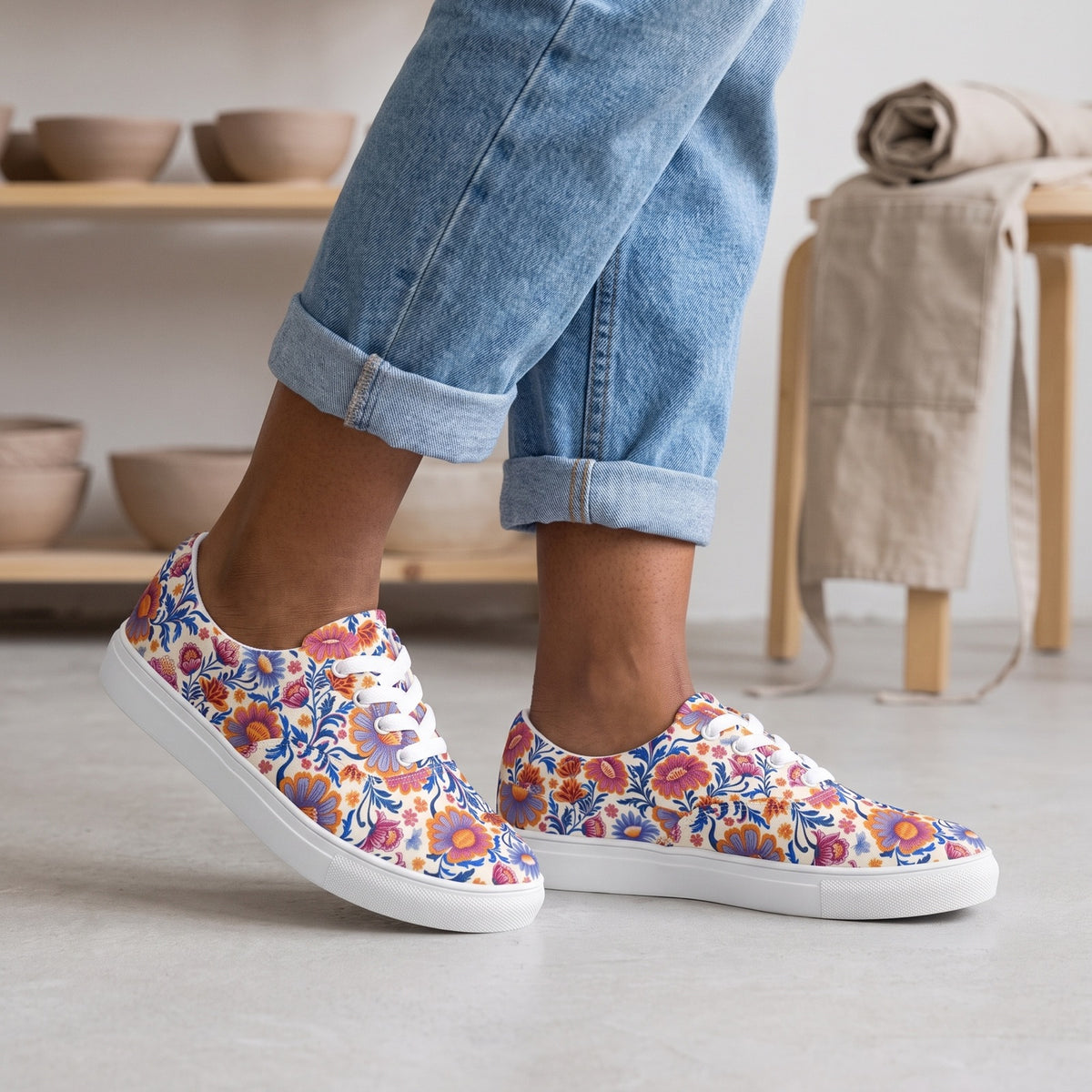 Spring Whimsy Ladies' Lace-up Canvas Sneakers — Airy pottery studio; clean concrete floor, clay bowls on distant shelving, rolled neutral apron on stool