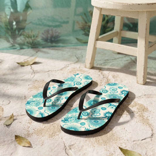 Surreal Sea Garden Flip Flops. Lifestyle scene: Marine botanical garden café; dry pale stone, cream stool, sea-green glass background