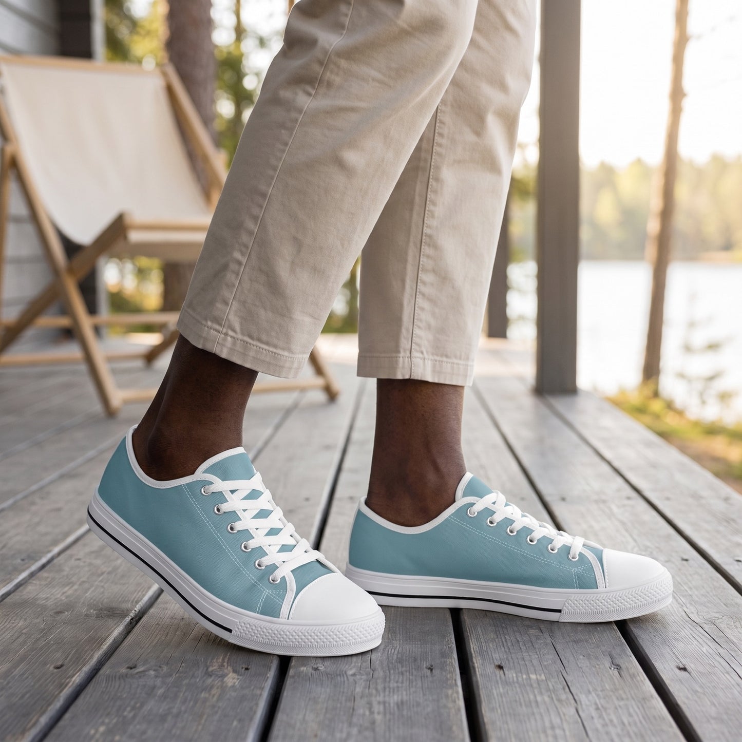 Glacial Ocean Men's Two-Tone Low Top Sneakers. Lifestyle scene: Lakeside lodge veranda; dry grey deck, cream canvas chair, crisp early daylight