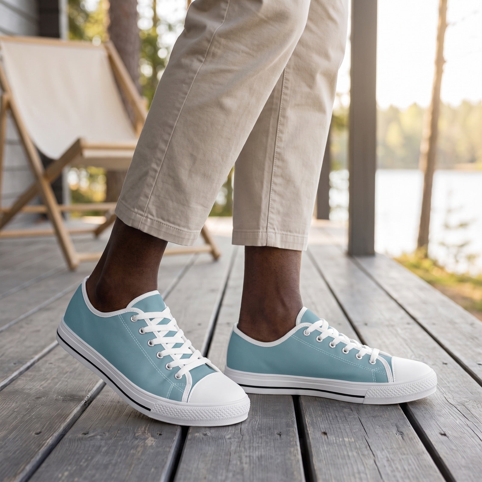 Glacial Ocean Men's Two-Tone Low Top Sneakers. Lifestyle scene: Lakeside lodge veranda; dry grey deck, cream canvas chair, crisp early daylight