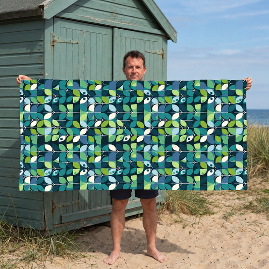 Man holding the 1960s Groovy Mod beach towel beside a beach hut.