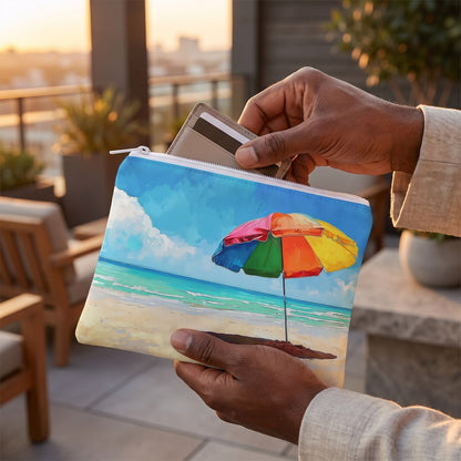 Small Tropical Tranquility accessory pouch (8.35 × 5.98 inches) in use: man slips a card wallet and keycard into pouch, linen jacket cuff visible. Lifestyle mockup with hands showing scale.