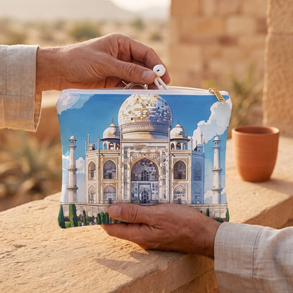 Small Majestic Taj Mahal Reflection accessory pouch (8.35 × 5.98 inches) in use: traveler packs earbuds into pouch on his lap, linen cuff and terracotta cup nearby. Lifestyle mockup with hands showing scale.
