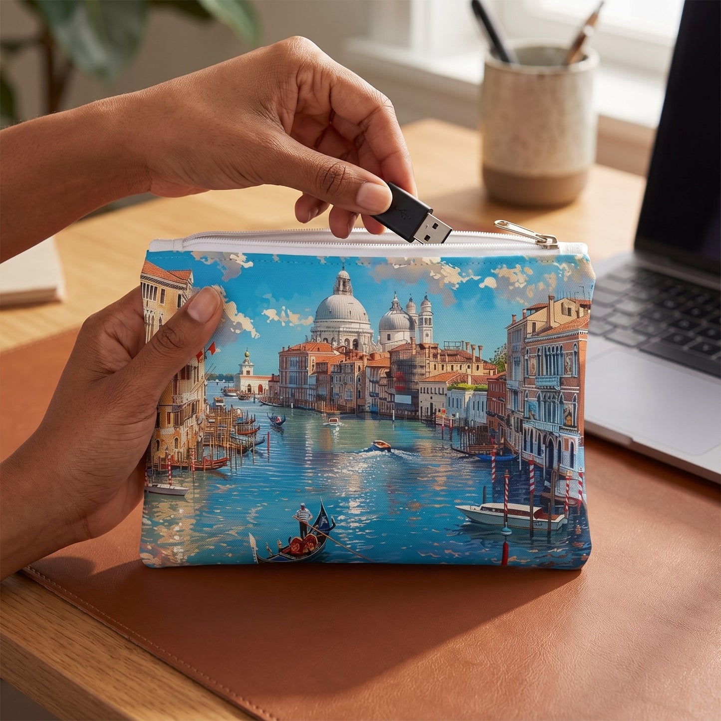 Small Venetian Grand Canal Dream accessory pouch (8.35 × 5.98 inches) in use: woman retrieves a USB adapter from pouch held in left hand. Lifestyle mockup with hands showing scale.