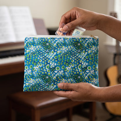 Small Embryonic Space Pods accessory pouch (8.35 × 5.98 inches) in use: pianist places earplugs and a tiny hand-cream tube in pouch, keys softly out of focus. Lifestyle mockup with hands showing scale.
