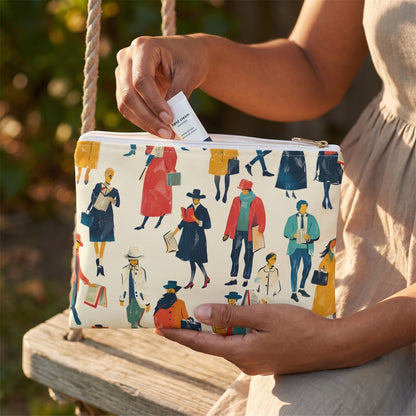 Small Literary People accessory pouch (8.35 × 5.98 inches) in use: woman retrieves a tiny hand cream from pouch, cotton dress and swing rope at margins. Lifestyle mockup with hands showing scale.