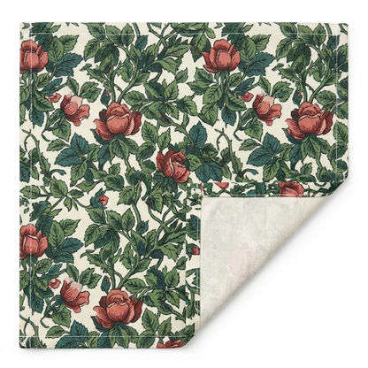 Close-up of Classic Red Rose & Vine cotton twill table runner showing the printed face, hemmed edge, white seam thread, and natural-white unprinted reverse