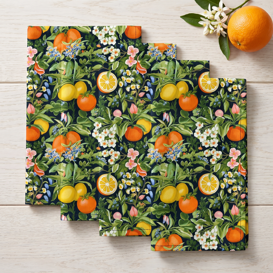 Four Classic Fruit & Floral dinner napkins in an elongated fold on light oak