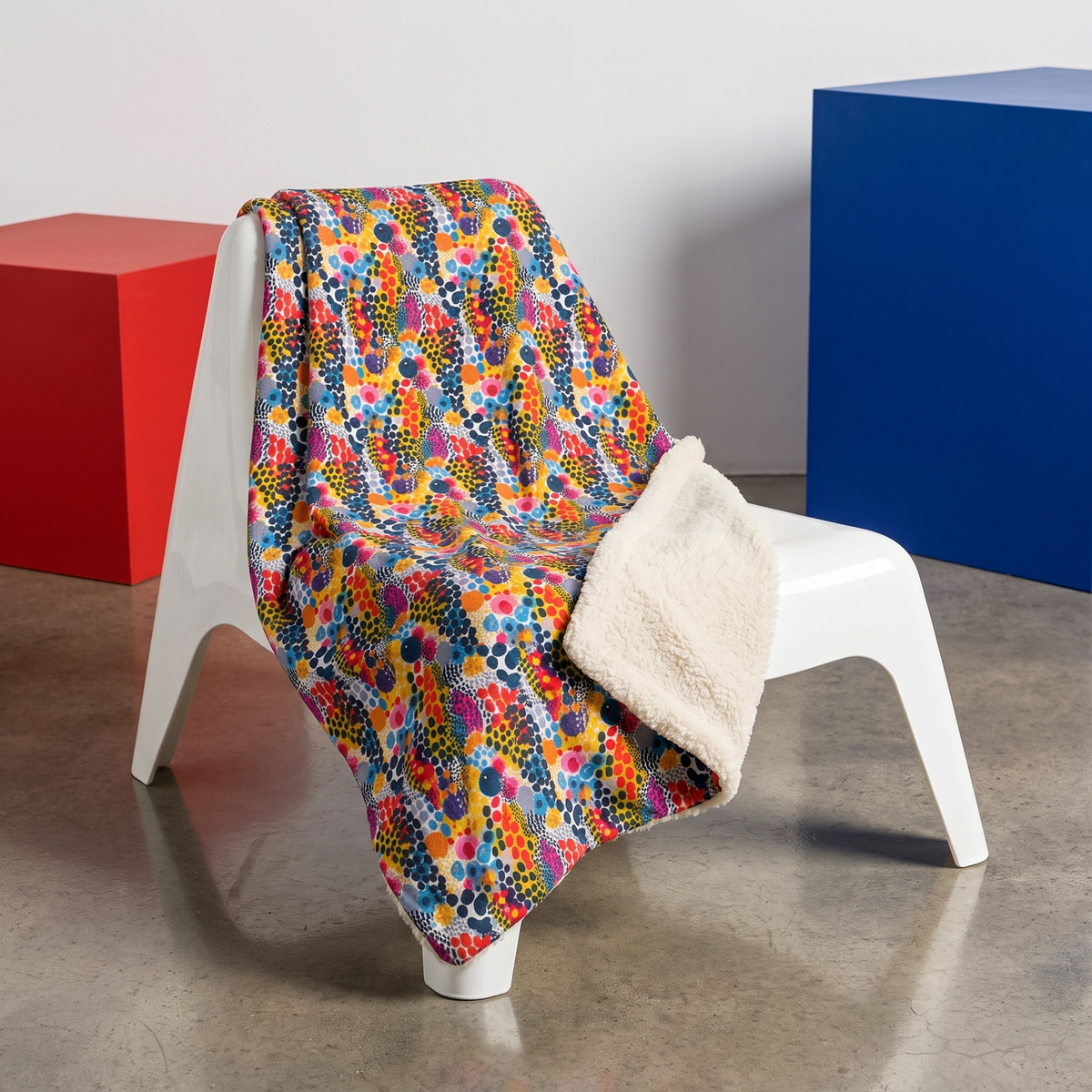 ColorSplash Pop sherpa fleece blanket on a molded white chair in a pop-art loft