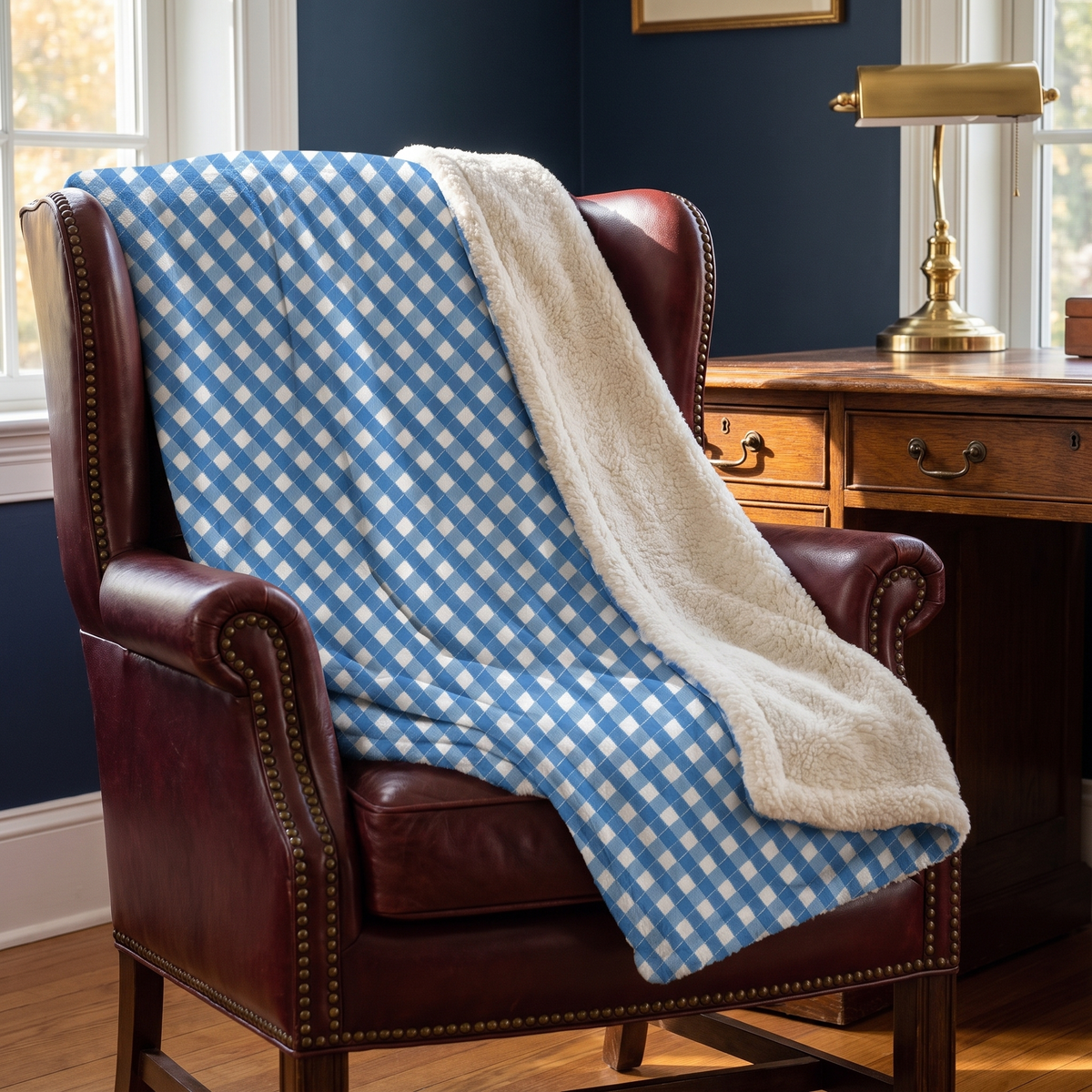 Modern Blue Ribbon sherpa fleece blanket on an oxblood leather club chair in a New England study