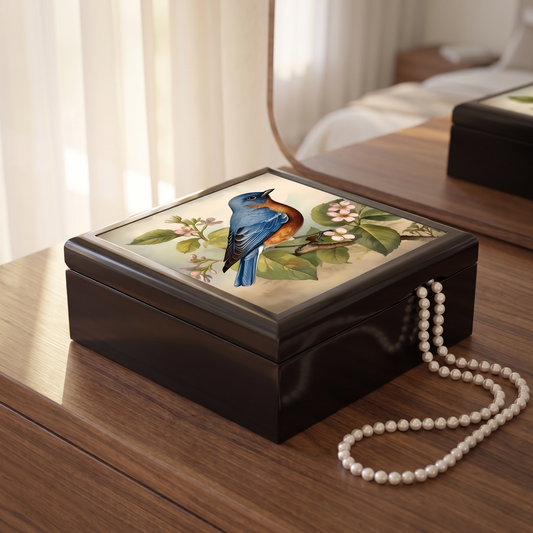 Bluebird Botanical jewelry box on a walnut dresser with a strand of pearls in soft morning light