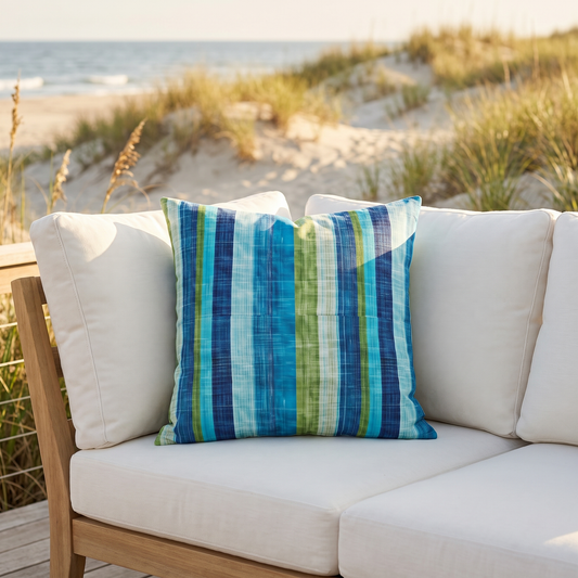 Ocean Whisper Stripes square outdoor pillow styled in a sunlit outdoor setting
