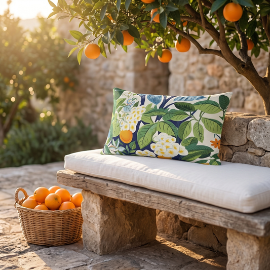 Happy Oranges & Blossoms outdoor lumbar pillow styled in a sunlit outdoor setting