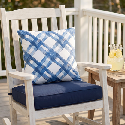 Blue Breeze Gingham square outdoor pillow styled in a sunlit outdoor setting