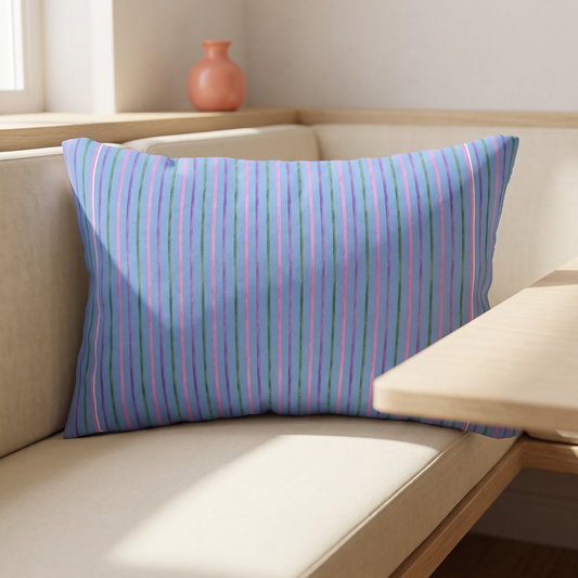 Candy Stripe blue lumbar pillow with pink purple and green stripes in a sunlit room