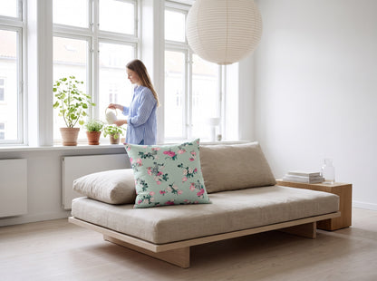 Delicate Rose Garden square throw pillow in a bright window-side living room